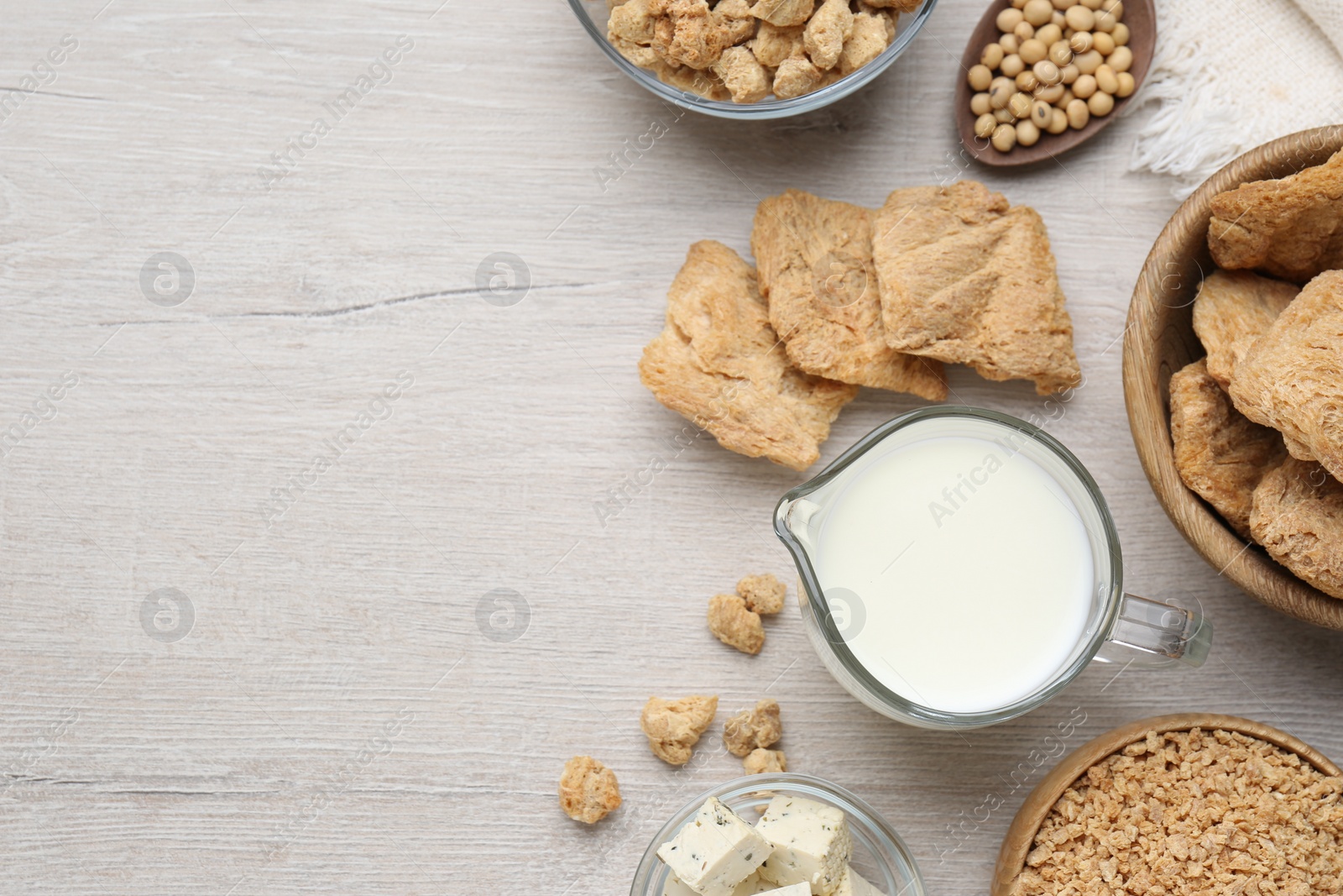 Photo of Different natural soy products on white wooden table, flat lay. Space for text