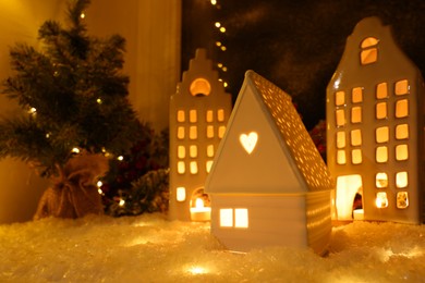 Photo of House shaped lanterns and Christmas decor on windowsill indoors, space for text