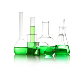 Photo of Different laboratory glassware with light green liquid isolated on white