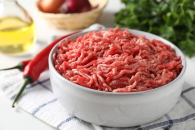 Photo of Raw ground meat in bowl on table, closeup