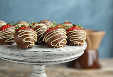 Photo of Dessert stand with chocolate covered strawberries on table, closeup