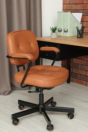 Comfortable office chair near desk at workplace