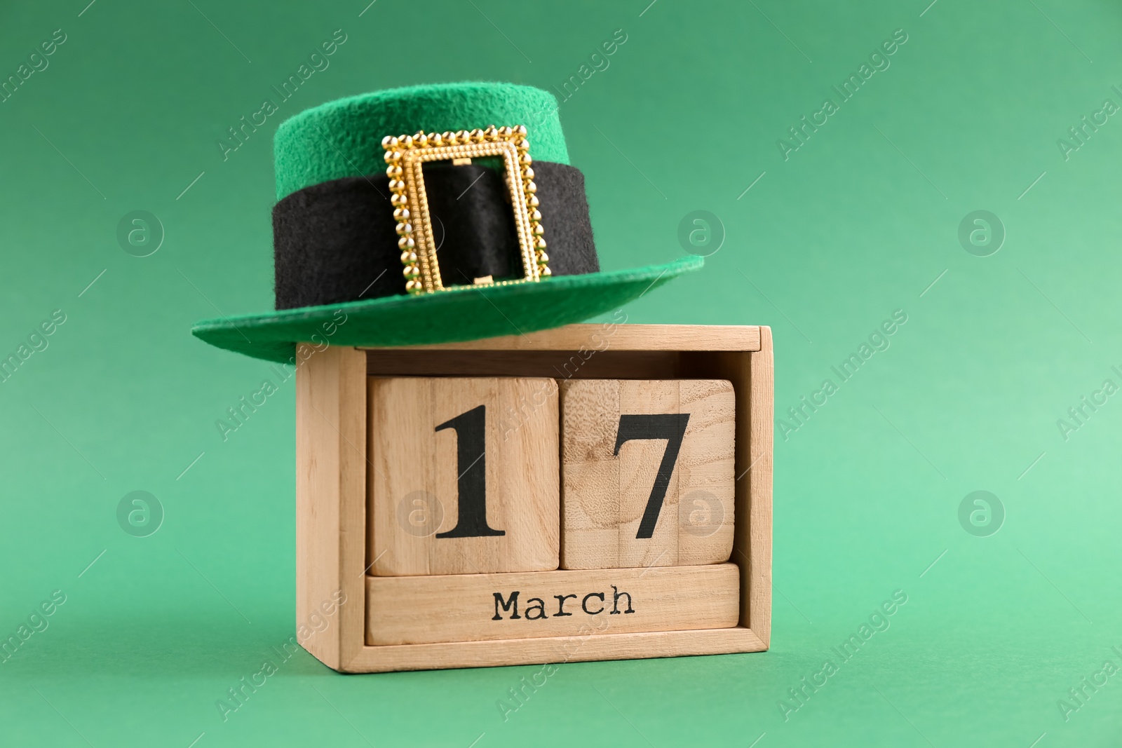 Photo of St. Patrick's day - 17th of March. Block calendar and leprechaun hat on green background