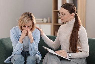 Psychotherapist working with patient on sofa in office