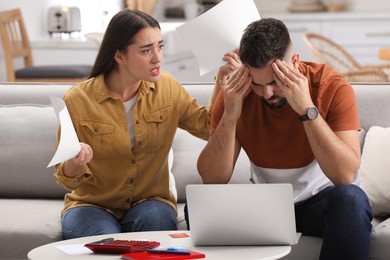 Photo of Young couple having argument about family budget at home