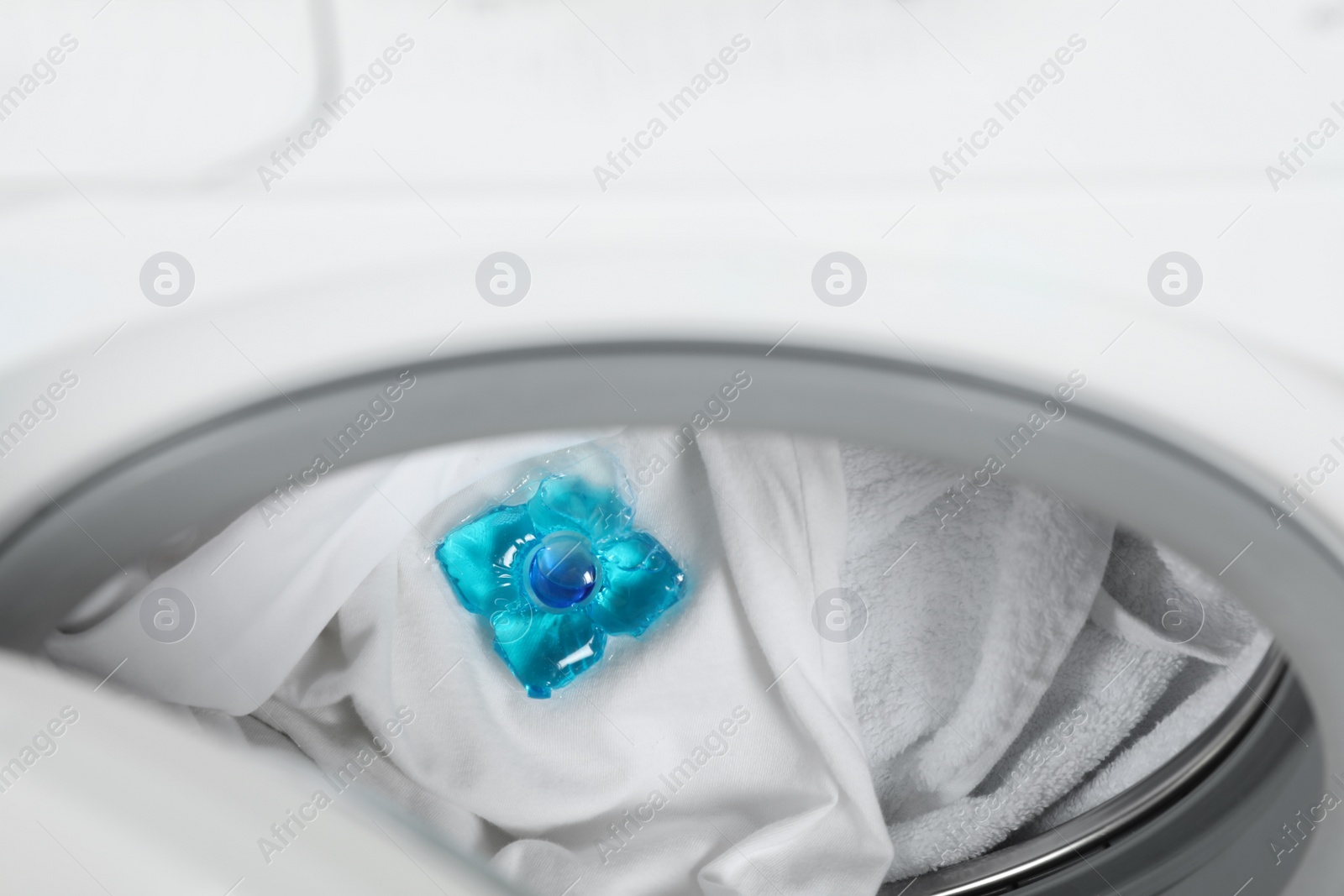 Photo of Laundry detergent capsule in washing machine drum, closeup view