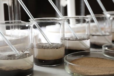 Photo of Glassware with soil samples and extracts on light table. Laboratory research