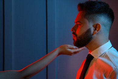 Photo of Woman touching handsome bearded man's face on light background. Color toned