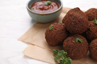 Photo of Vegan meat products. Delicious falafel balls and parsley on white table, closeup. Space for text