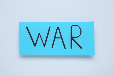 Photo of Card with word War on white background, top view