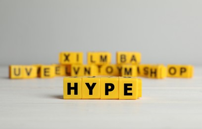 Word Hype of yellow cubes with letters on white table