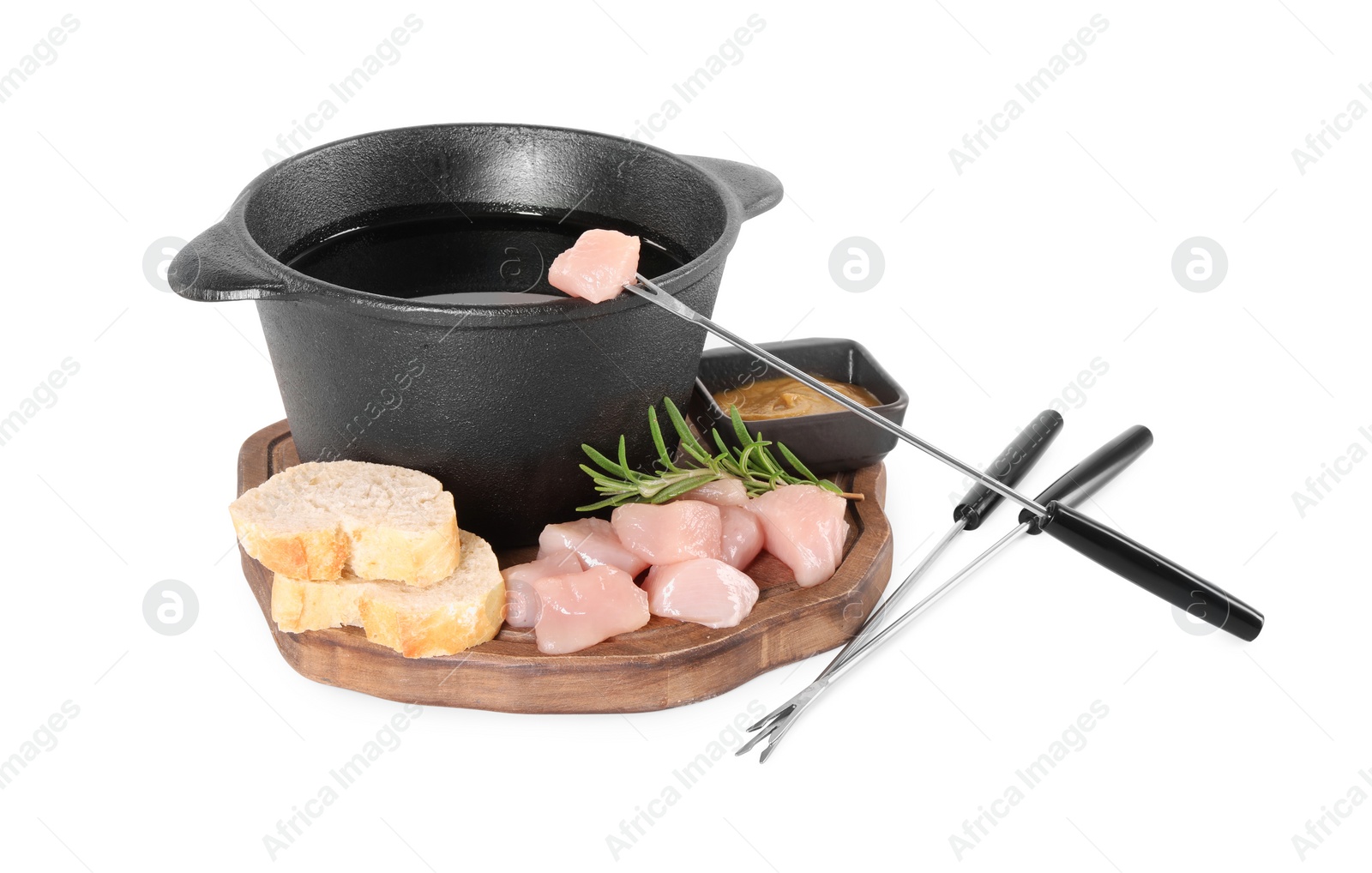 Photo of Fondue pot with oil, forks, raw meat pieces and other products isolated on white