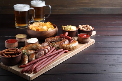 Set of different tasty snacks and beer on wooden table, space for text