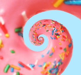 Image of Twisted donut with strawberry icing and sprinkles on pale light blue background, spiral effect