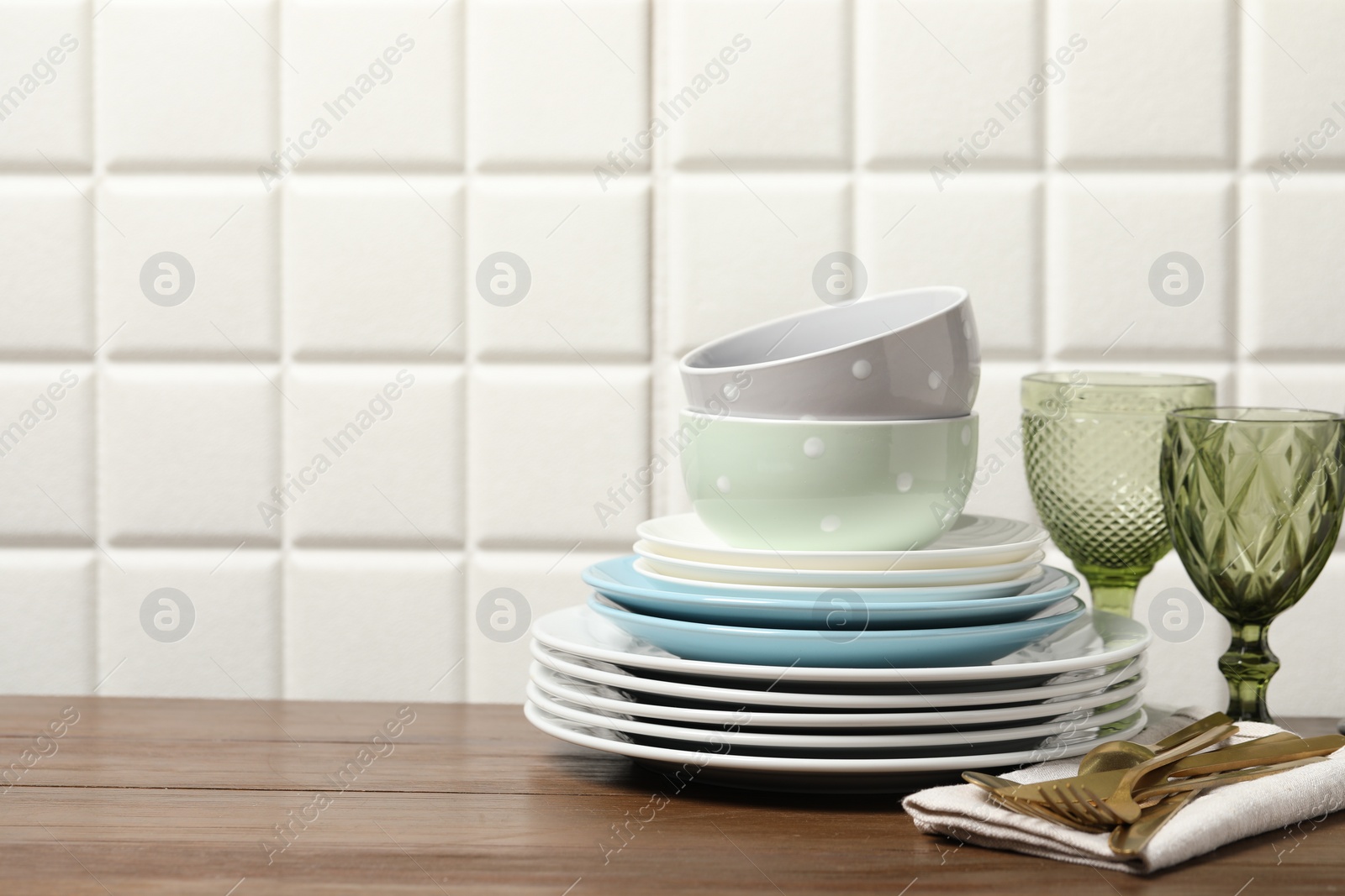 Photo of Beautiful ceramic dishware, glasses and cutlery on wooden table, space for text