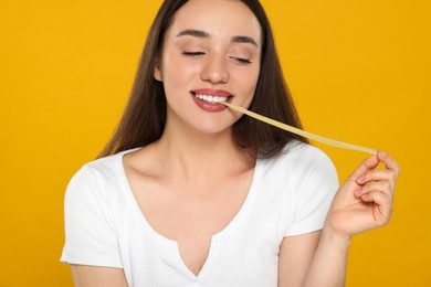 Photo of Happy young woman with bubble gum on yellow background