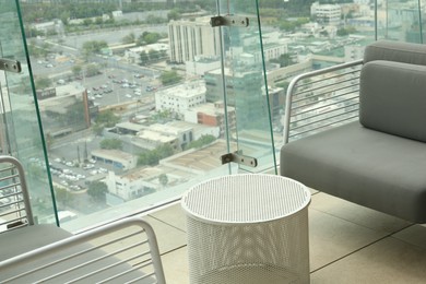 Coffee table and sofa against picturesque landscape of city in cafe