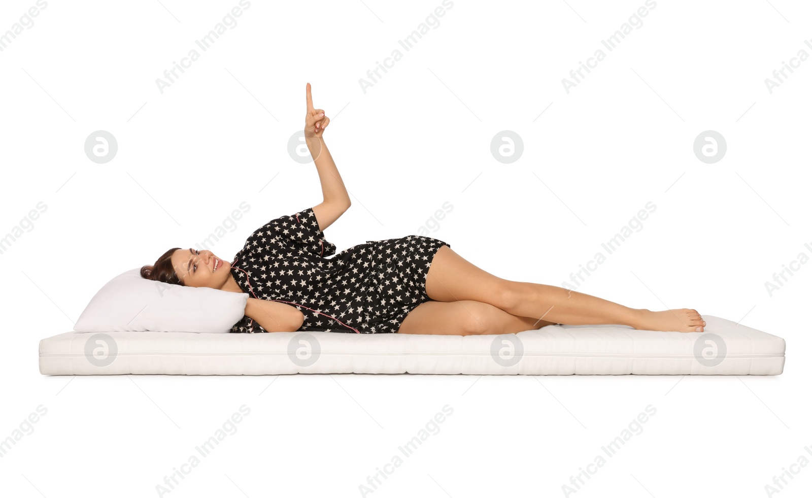 Photo of Woman lying on soft mattress and pointing upwards against white background