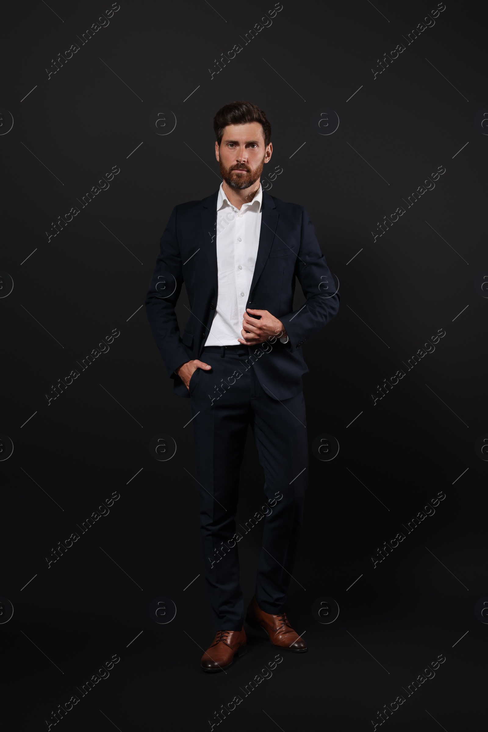 Photo of Handsome bearded man in suit on black background