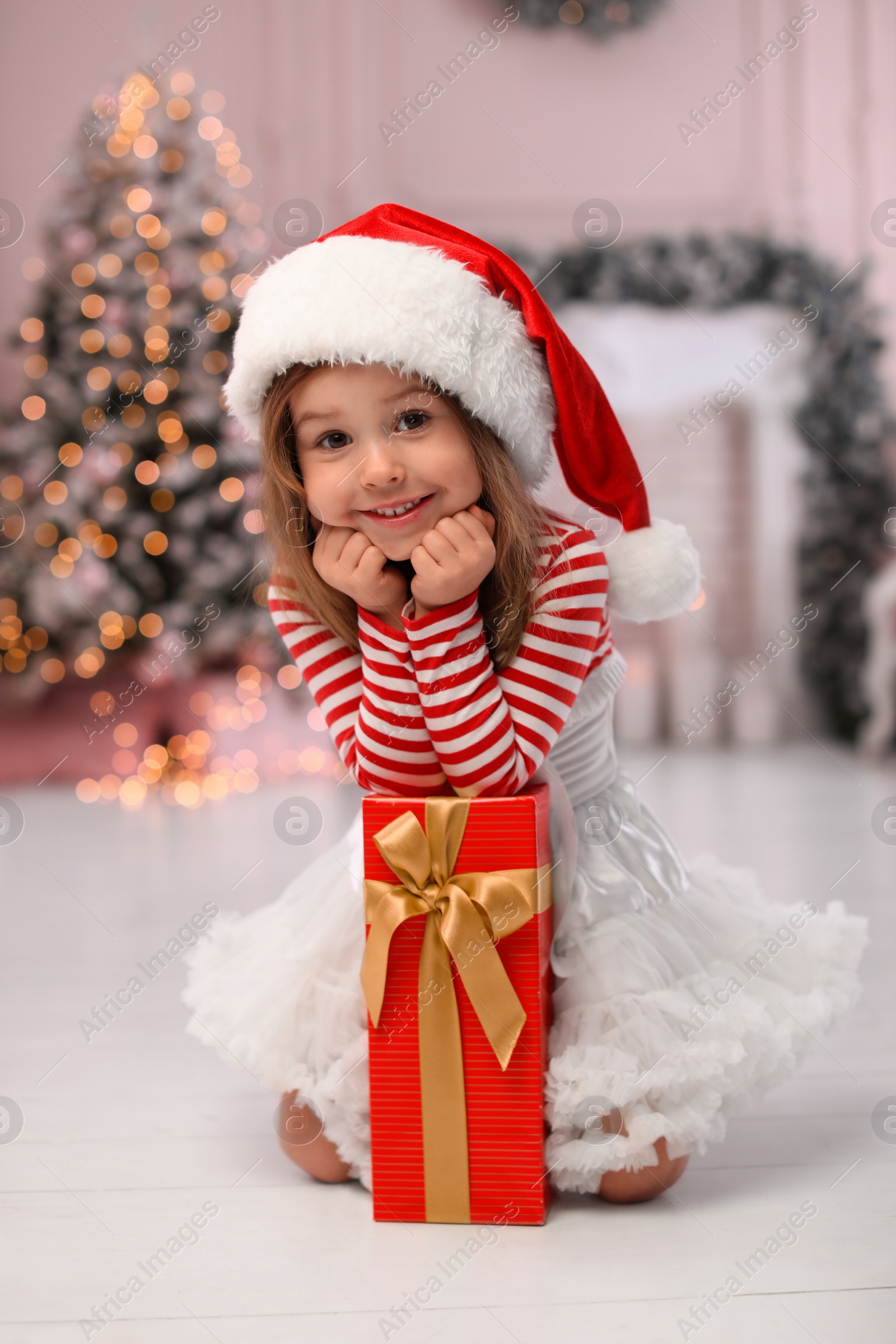 Photo of Cute little child with Christmas gift at home