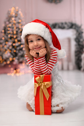 Cute little child with Christmas gift at home