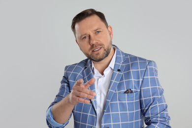 Portrait of emotional mature man on light grey background