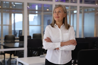 Smiling woman with crossed arms in office, space for text. Lawyer, businesswoman, accountant or manager