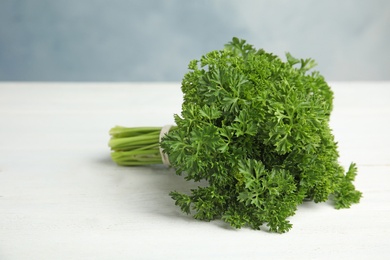 Photo of Bunch of fresh green parsley on white wooden table