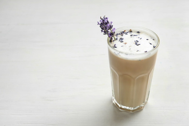 Delicious coffee with lavender on white wooden table. Space for text