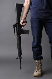 Assault gun. Man holding rifle on dark background, closeup