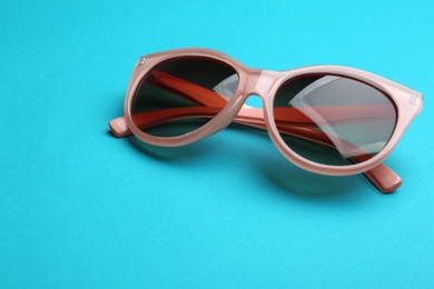 Stylish sunglasses on blue background. Fashionable accessory