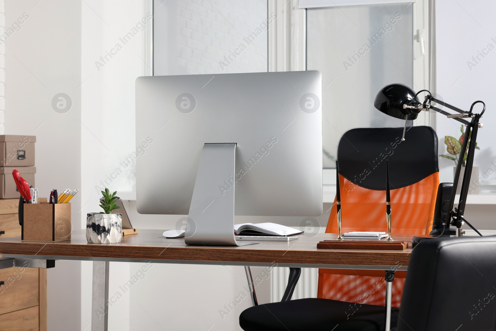 Photo of Stylish director's workplace with comfortable furniture, computer and accessories in office. Interior design