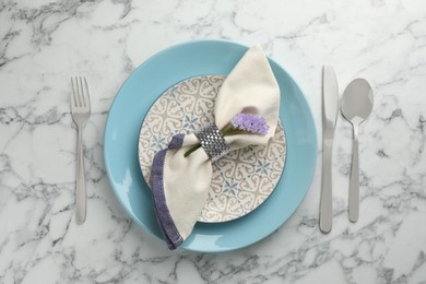 Photo of Stylish setting with cutlery and plates on white marble table, flat lay