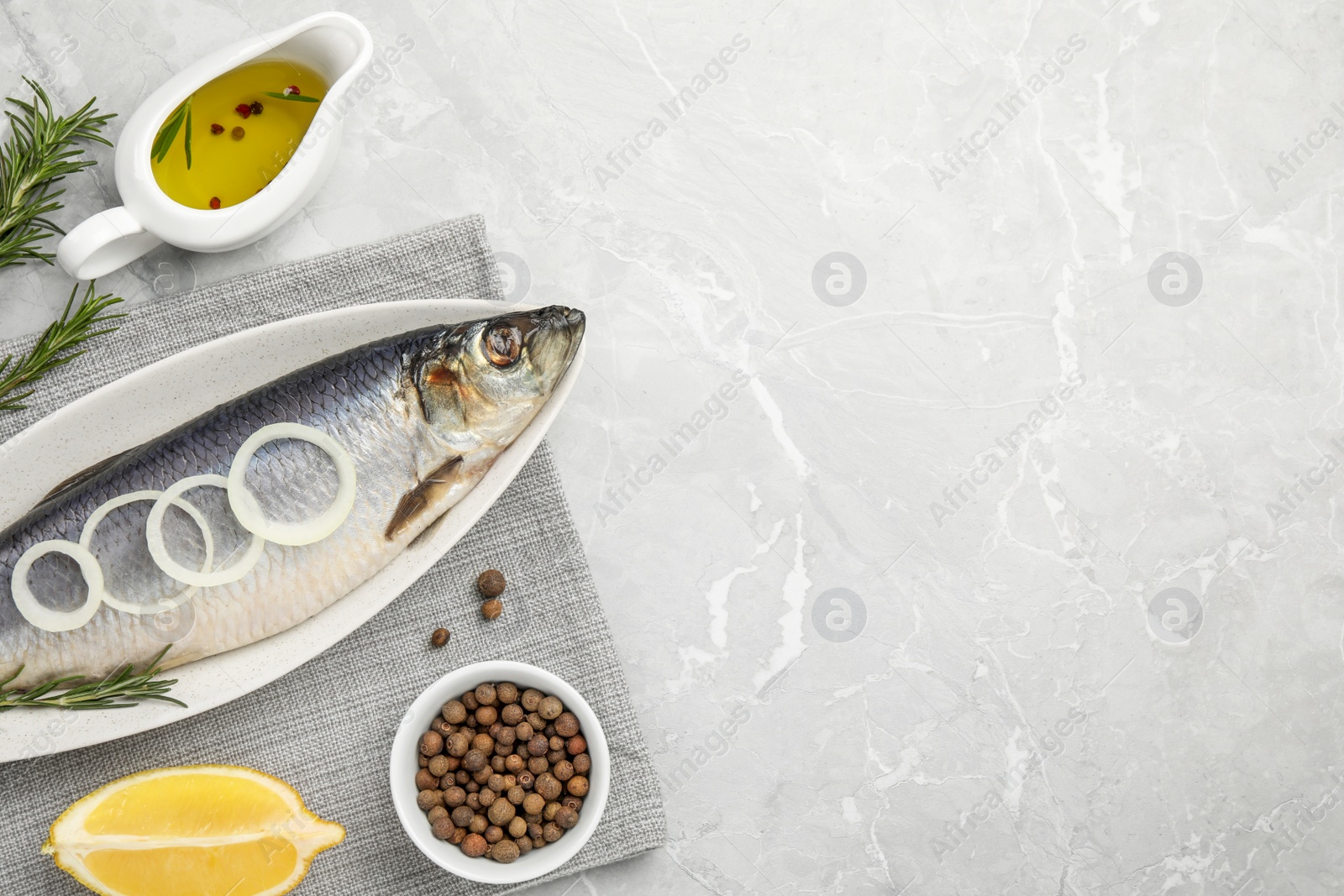 Photo of Delicious salted herring and ingredients on light grey table, flat lay. Space for text