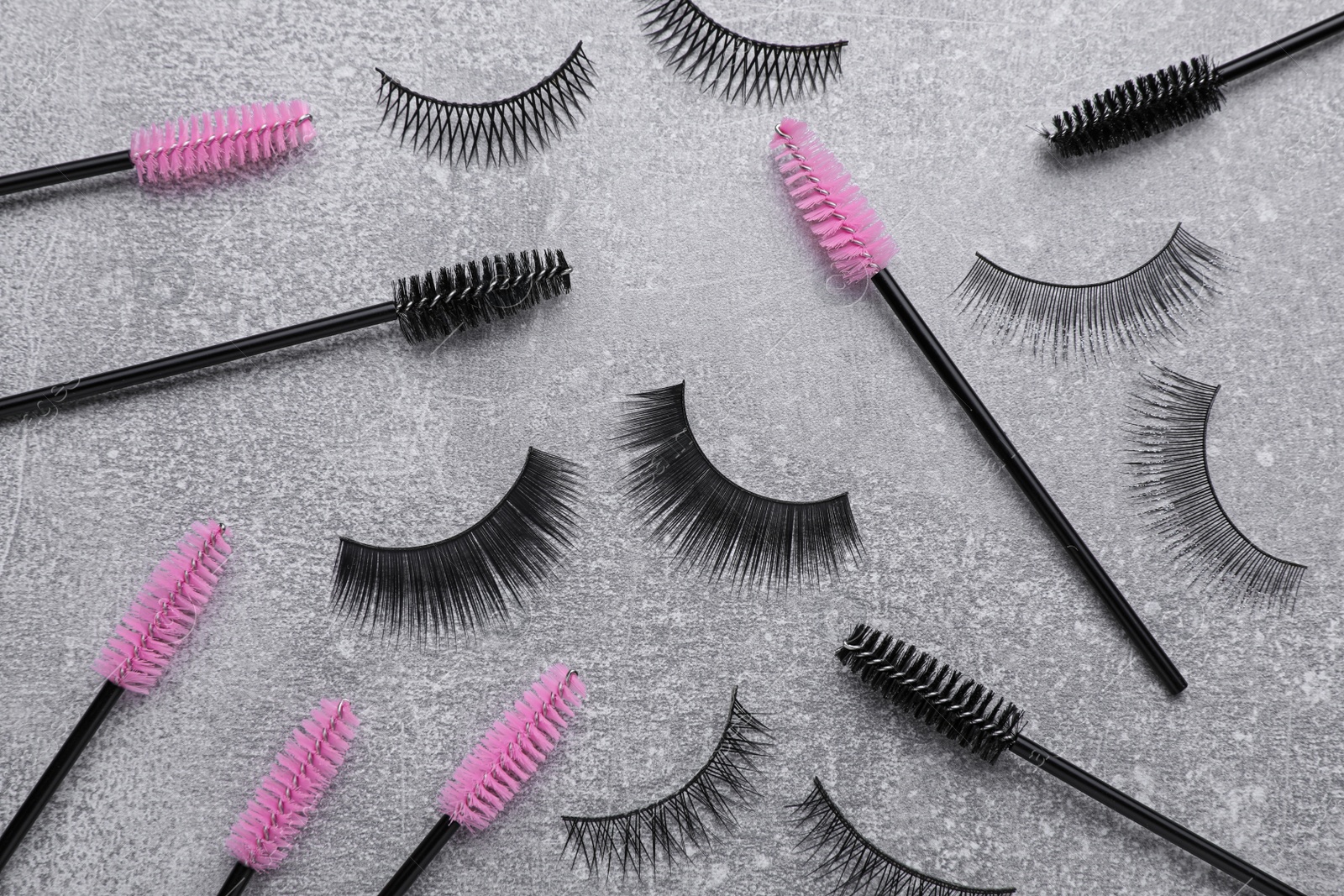 Photo of Flat lay composition with false eyelashes and brushes on light grey background