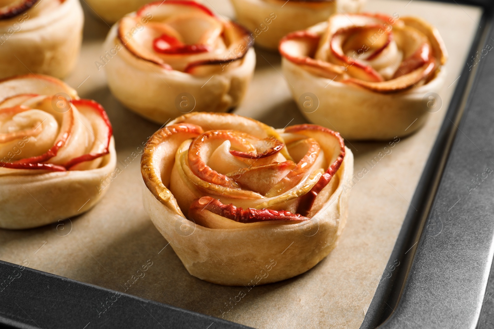 Photo of Tray with freshly baked apple roses, closeup view. Beautiful dessert