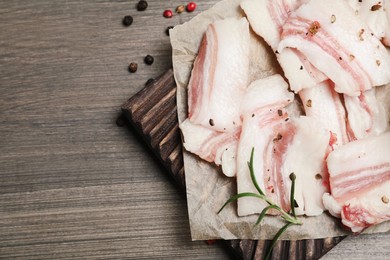 Tasty salt pork with rosemary and spices on wooden table, flat lay. Space for text