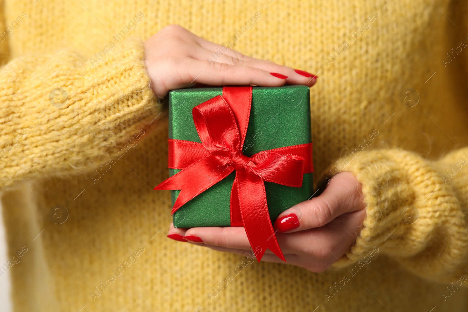 Photo of Christmas present. Woman holding gift box, closeup