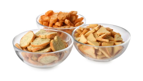 Photo of Different crispy rusks in bowls on white background