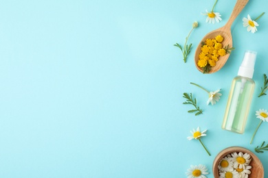 Flat lay composition with bottle of essential oil and flowers on color background, space for text