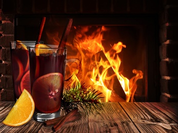 Mulled wine on wooden table near fireplace