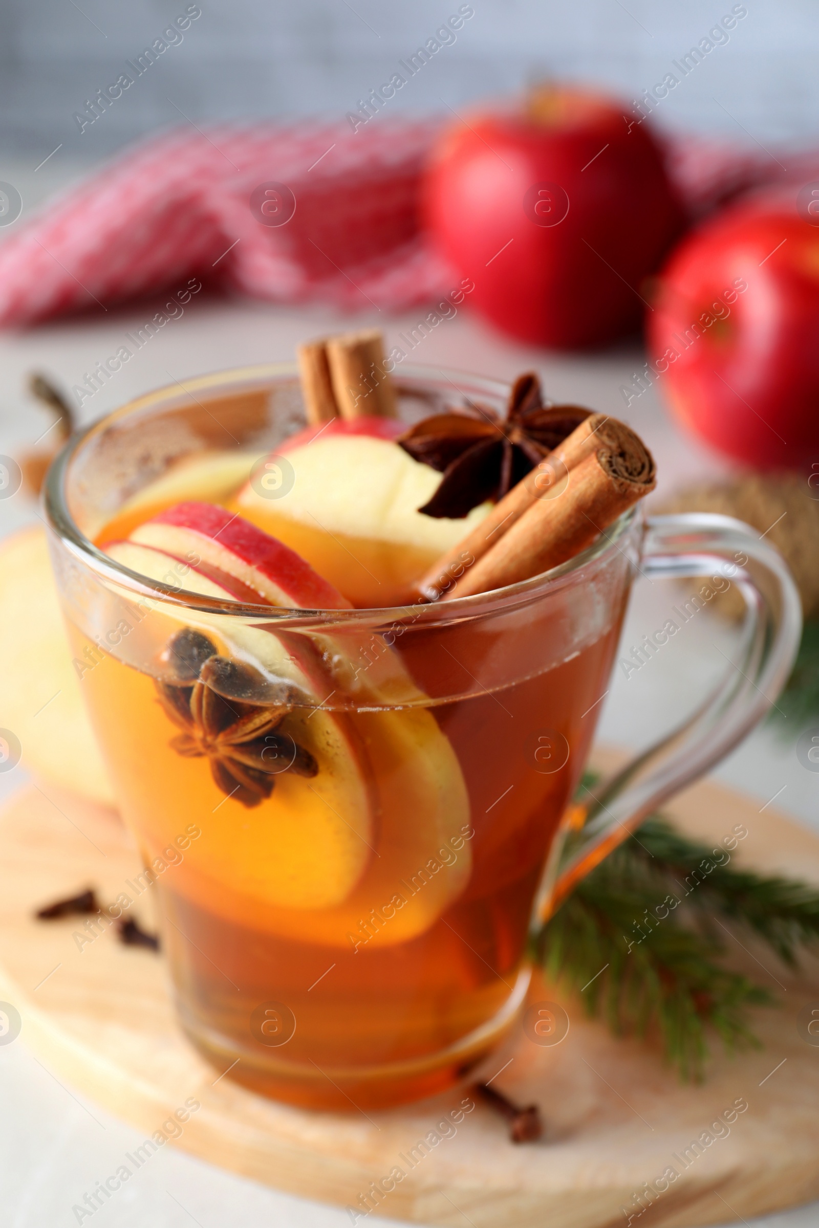 Photo of Aromatic hot mulled cider on wooden board