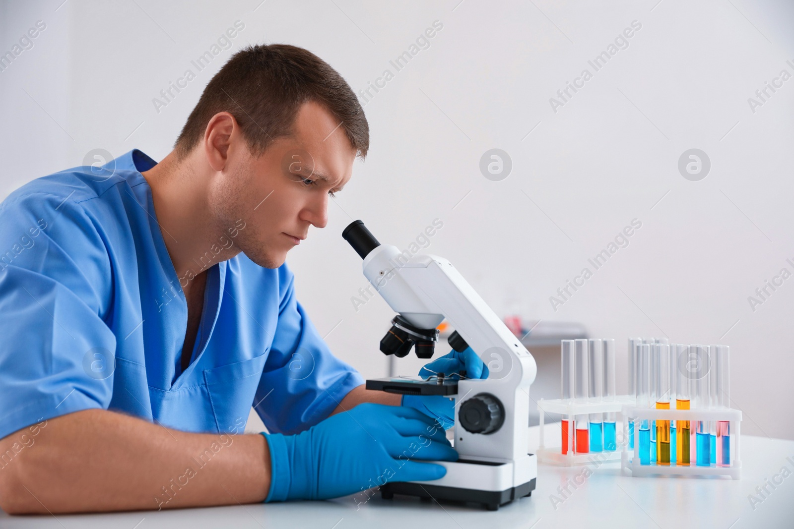 Photo of Scientist using modern microscope at table. Medical research