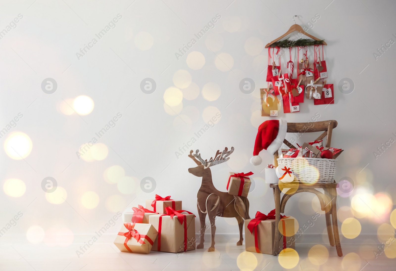 Image of Advent calendar, Christmas gifts and decor near white wall indoors, space for text