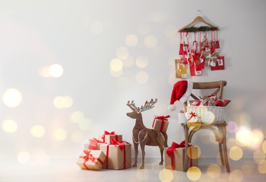 Image of Advent calendar, Christmas gifts and decor near white wall indoors, space for text