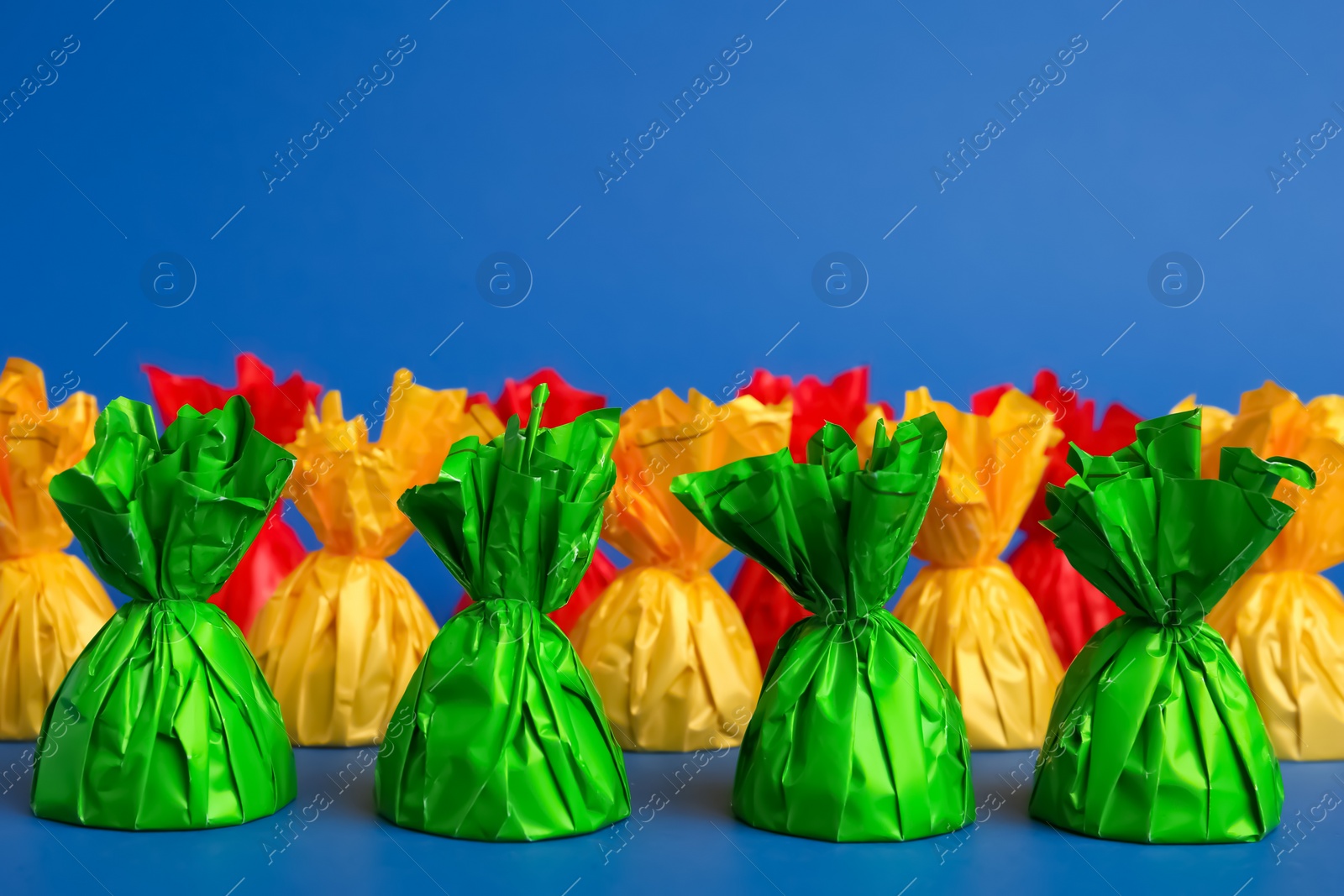 Photo of Candies in colorful wrappers on blue background