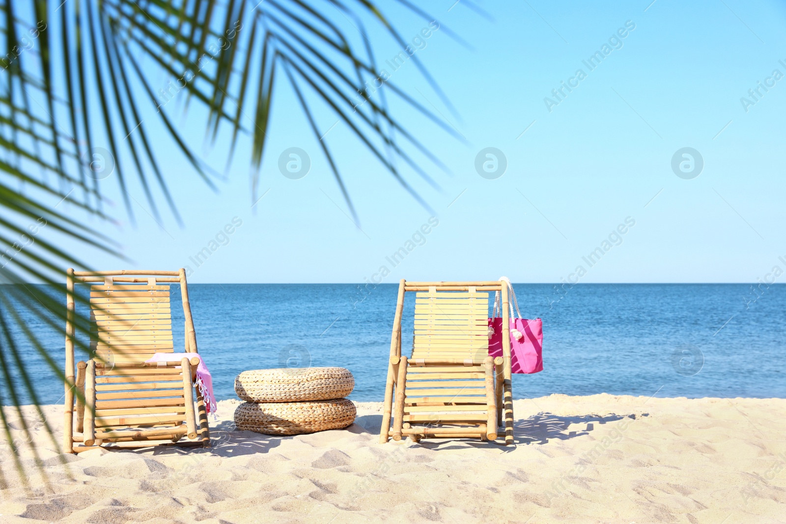 Photo of Wooden sunbeds and beach accessories on sandy shore