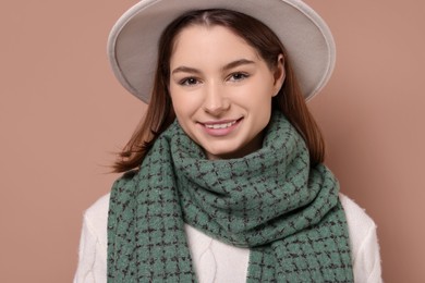 Photo of Beautiful woman in warm scarf and hat on brown background