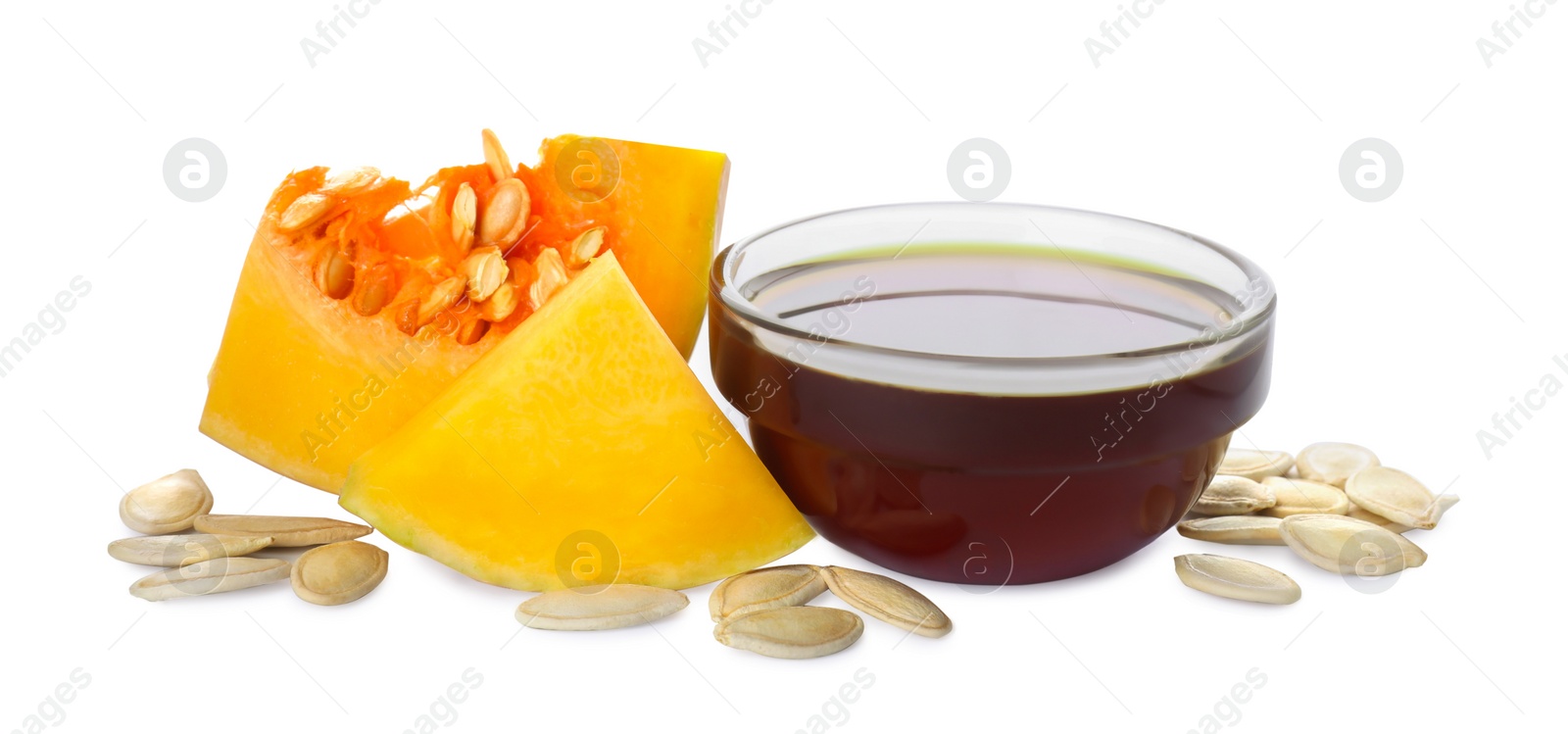 Photo of Fresh pumpkin seed oil in glass bowl isolated on white