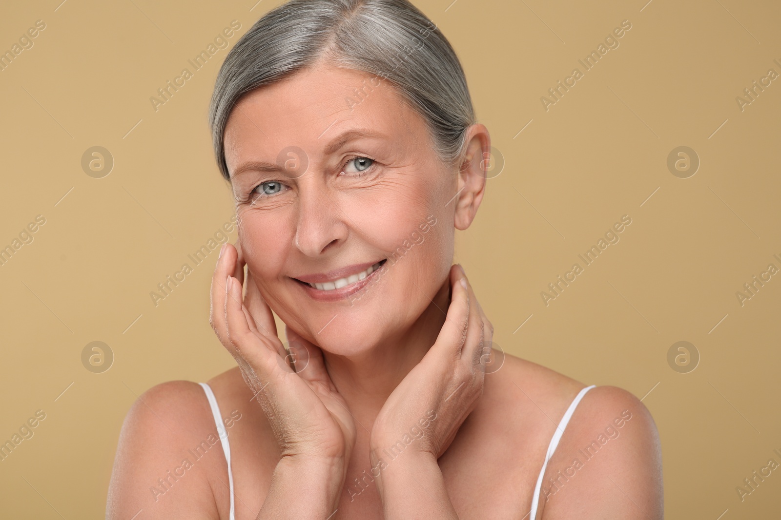 Photo of Portrait of senior woman with aging skin on beige background. Rejuvenation treatment